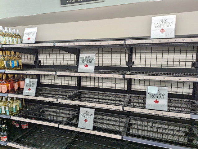 photograph of some empty store shelves in canada with buy canadian instead signs